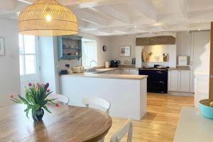 a kitchen and dining room with a wooden table at Folly Farm Cottage, Cosy, Secluded near to St Ives in St Ives
