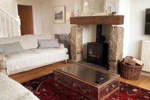 a living room with a couch and a fireplace at Folly Farm Cottage, Cosy, Secluded near to St Ives in St Ives