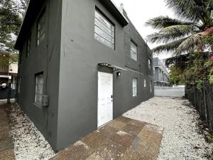 un edificio con dos puertas blancas de garaje y una valla en friendly Hidden Miami Little Havana Gem, en Miami