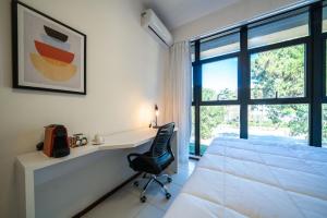 1 dormitorio con escritorio, 1 cama y ventana en Tabas - Edifício Studio In - Brasília, en Brasilia