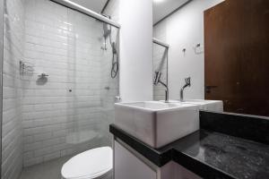 a white bathroom with a sink and a toilet at Tabas - Edifício Studio In - Brasília in Brasilia
