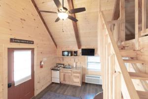 a kitchen with a ceiling fan in a wooden cabin at Sun Outdoors Pigeon Forge in Sevierville