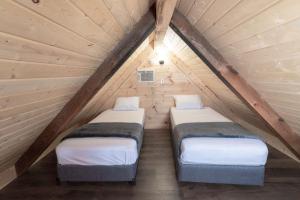 two beds in a attic bedroom with a roof at Sun Outdoors Pigeon Forge in Sevierville