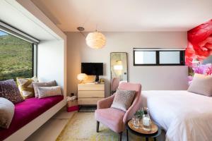 1 dormitorio con cama, sofá y espejo en Vyn Guest House Hout Bay en Hout Bay