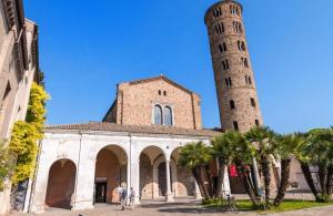 two towers of a church with palm trees in front at Ravenna Suite in Ravenna
