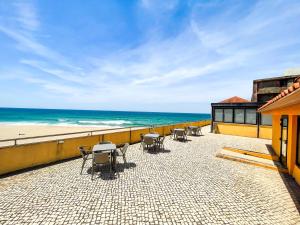 a patio with chairs and the ocean in the background at HI Areia Branca - Pousada de Juventude in Areia Branca