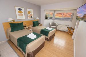 um quarto de hotel com duas camas e uma secretária em Hotel Plaza Bariloche em San Carlos de Bariloche