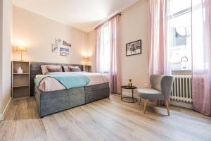 a bedroom with a bed and a chair and a window at Entspannen in unserer gemütlichen Suite A in Bad Camberg