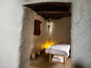 Explora en Atacama - All Inclusive في سان بيدرو دي أتاكاما: غرفة بسرير ابيض بجدار ابيض