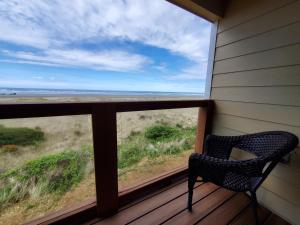 a chair on a porch with a view of the ocean at Moonstone Beach Motel in Moclips