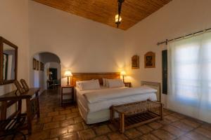 Un dormitorio con una gran cama blanca y una mesa en Hotel El Manantial del Silencio en Purmamarca