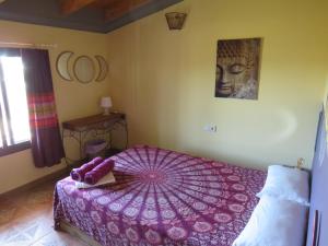Un dormitorio con una cama morada con una sombrilla. en HIGOS CHUMBOS, CASA RURAL COMPARTIDO, en Chiclana de la Frontera