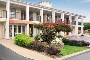 a large building with flowers in front of it at Super 8 by Wyndham Garner/Clayton/Raleigh in Garner