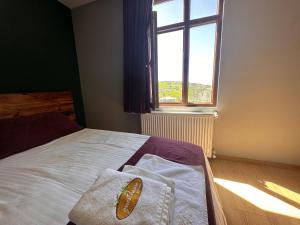 a bedroom with a white bed with a window at Zeytindalı Yayla Hotel in Hackali Baba Yaylasi