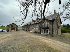 una vieja casa de piedra en un camino de tierra en Royal Portrush Golfing Accommodation at The Flax Mill, en Coleraine