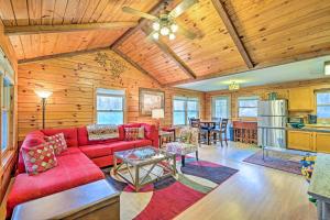 a living room with a red couch and a table at High Peak Heaven Cozy Log Cabin on 1 Acre! in Windham