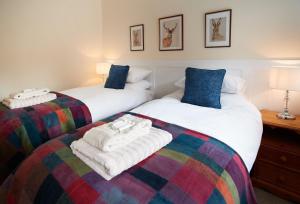 Duas camas num quarto com toalhas em Evenwood Byre em Kenley