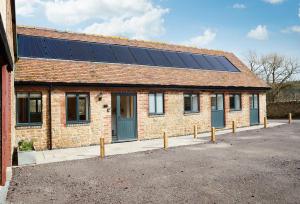 uma casa com painéis solares no telhado em Evenwood Byre em Kenley