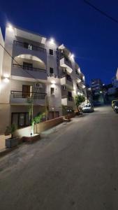a large white building with cars parked in front of it at Amaryllis Hotel in Karpathos