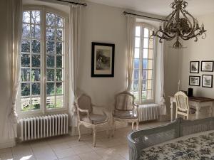 Una sala de estar con un sofá y sillas y ventanas. en Le Bouquet Bleu Bed and Breakfast, en Siorac-en-Périgord