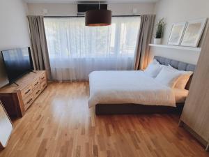 a bedroom with a large bed and a television at A romantic seaside retreat for two in Meremõisa