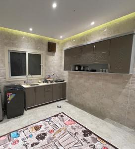 uma cozinha com armários cinzentos, um lavatório e um tapete em B-Home 2 no Cairo