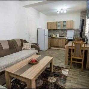 a living room with a couch and a table and a kitchen at Apartman NIKOLIJA 1 in Bajina Bašta