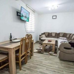 un soggiorno con un tavolo e un divano di Apartman NIKOLIJA 1 a Bajina Bašta