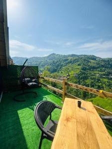 a wooden table and chairs on a balcony with a view at sataplebungalov in Çamlıhemşin