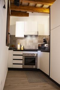 una cucina con armadietti bianchi e piano cottura di casa vacanza zu ciano a Marausa