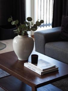 a vase sitting on a coffee table with a book at Central Mountain Penthouse Getaway, Strandafjellet in Stranda