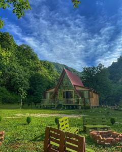 a wooden cabin with yellow chairs in front of it at nahei cottage in Martvili