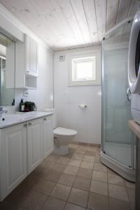 a white bathroom with a toilet and a shower at Central Mountain Penthouse Getaway, Strandafjellet in Stranda