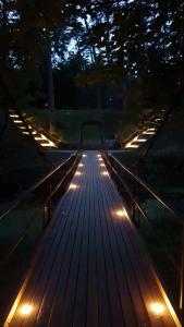 a wooden boardwalk with lights on it at night at A romantic seaside retreat for two in Meremõisa