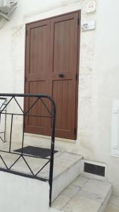 una puerta a un edificio con una silla delante en Muri de mainè, en Ostuni