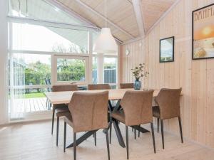 a dining room with a wooden table and chairs at 6 person holiday home in Hemmet in Falen