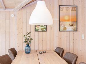 a dining room with a table and a vase with flowers at 6 person holiday home in Hemmet in Falen