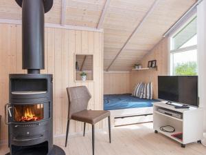 a living room with a stove and a desk and a couch at 6 person holiday home in Hemmet in Falen