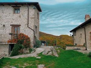 un bâtiment en pierre avec un chemin menant à une maison dans l'établissement La casa della Rocca, 
