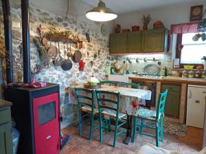 a kitchen with a table and chairs in a room at La casa della Rocca 