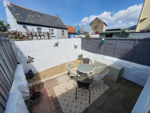 a patio with a table and chairs and a fence at CurLi Cottage in Bideford