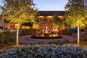 a large sculpture in front of a building with trees and flowers at The Lodge at Sonoma Resort, Autograph Collection in Sonoma