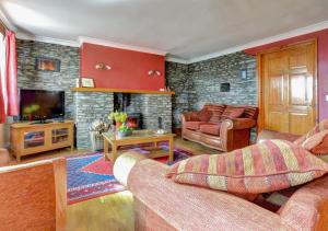 a living room with two couches and a fireplace at Hen Ysgubor in Lampeter