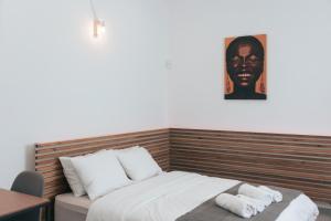 um quarto com uma cama com uma fotografia na parede em Athena City Apartment em Atenas