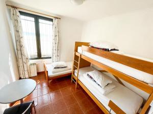 阿雷亞布蘭卡的住宿－HI Areia Branca - Pousada de Juventude，客房设有两张双层床和一张桌子。