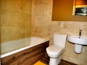 a bathroom with a toilet and a sink and a bath tub at Stunningly Opulent Gold Apartment Near Sheffield FULL SKY TV in Rotherham