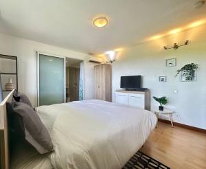a bedroom with a large white bed and a television at View apartment - St Barts in Marigot
