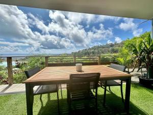 a wooden table and chairs on a deck with a view at View apartment - St Barts in Marigot