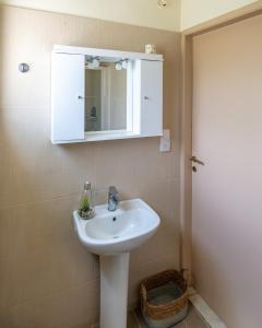 a bathroom with a white sink and a mirror at Casa Cicala in Pómbia