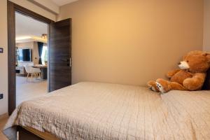 a teddy bear sitting on a bed in a bedroom at DOLLY LUX in Crikvenica